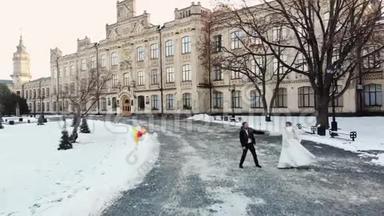 冬季婚礼。 身着婚纱的新婚夫妇在白雪覆盖的公园里跳着婚礼舞
